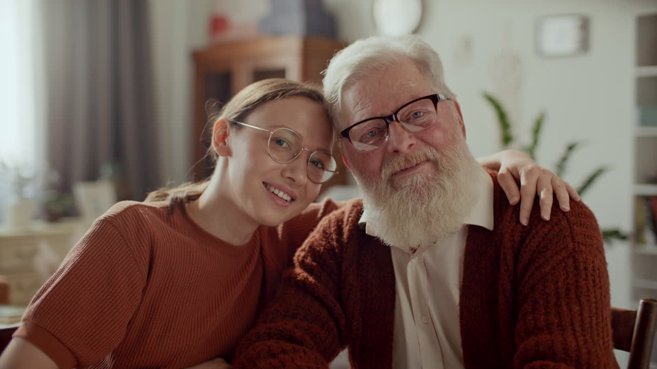 Portrait of Happy Woman Hugging Elderly Grandfather at Home
