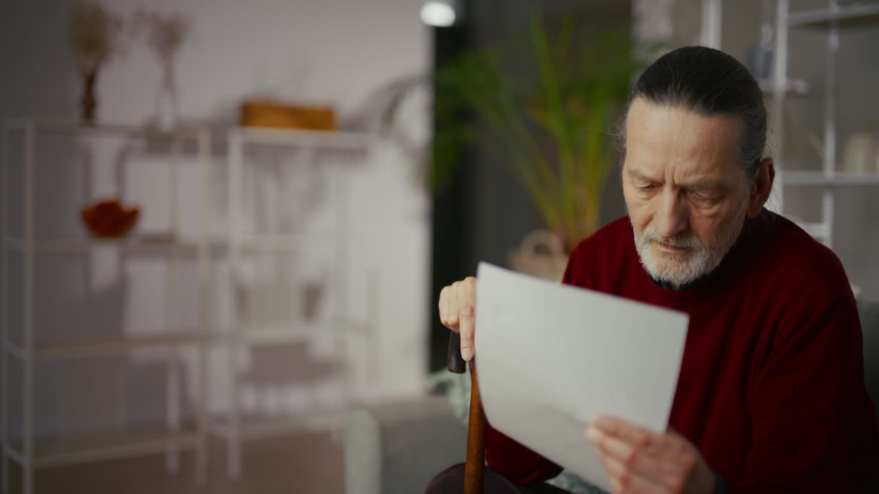 Elderly Man Reading a Document with a Concerned Expression