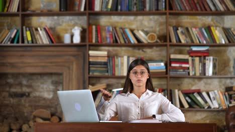 mujer trabajando en un escritorio en una biblioteca