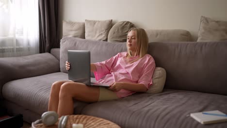 mujer joven trabajando desde casa en una computadora portátil