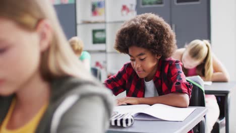 Porträt-Glücklicher,-Vielfältiger-Schulkinder-An-Schreibtischen-Im-Klassenzimmer