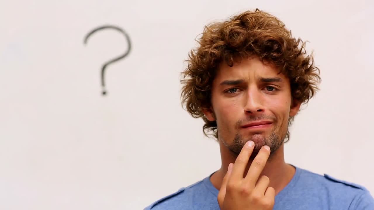 estudiante confundido de pie frente a la pizarra con un signo de interrogación