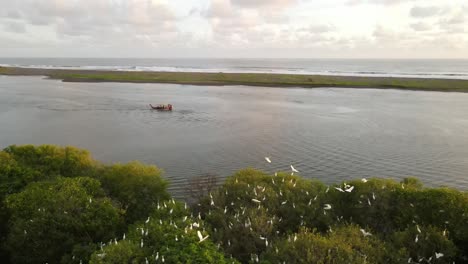 the-aerial-view,-the-boats-sailing-in-the-lagoon-at-sunset-looks-very-beautiful