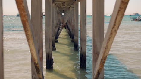 underneath an old wooden pier looking out to sea