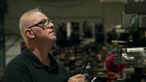 man with clipboard in factory