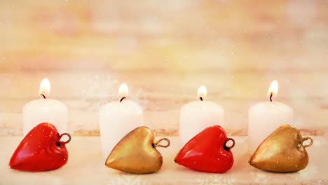velas y decoración navideña combinadas con la nieve que cae