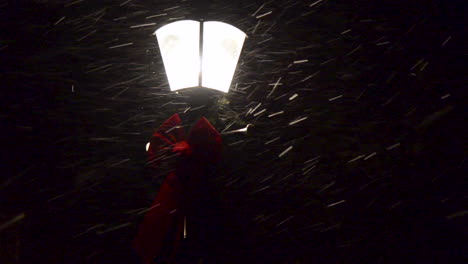 冬の夜、美しい古い街灯の周りに雪が降る