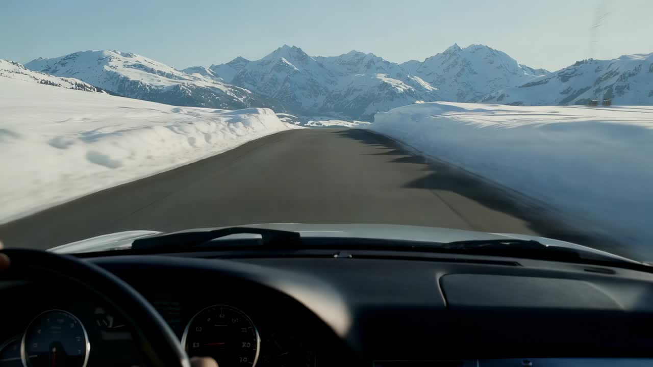Driving driver viewpoint moving down cleared mountain pass, left hand steering wheel guiding