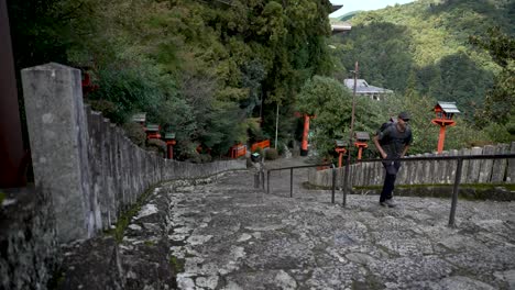 male tourist climbing stairs to nachi taisha shrine in nachikatsuura, wakayama prefecture, japan