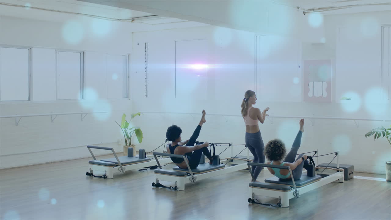 운동 수업에 참여하는 사람들을 안내하고, 밝은 스튜디오에서 피트니스 루틴을 이끌고 있는 강사