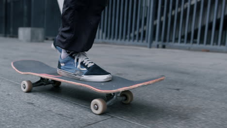 unrecognizable skater riding outdoor. man feet jumping on skateboard at street.