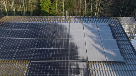 Toma-Aérea-De-Seguimiento-Frente-A-Colectores-De-Luz-Solar-Helada-En-El-Techo-De-Una-Casa.