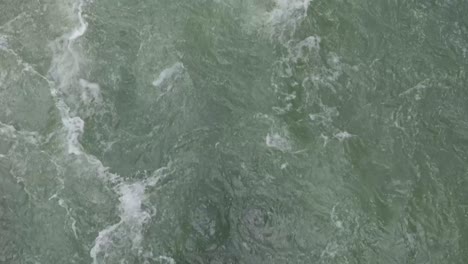 aerial top down view of swirling water in rushing river