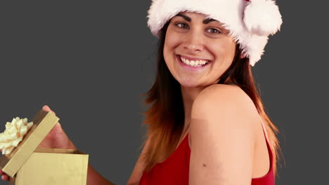 una morena festiva abriendo un regalo de navidad