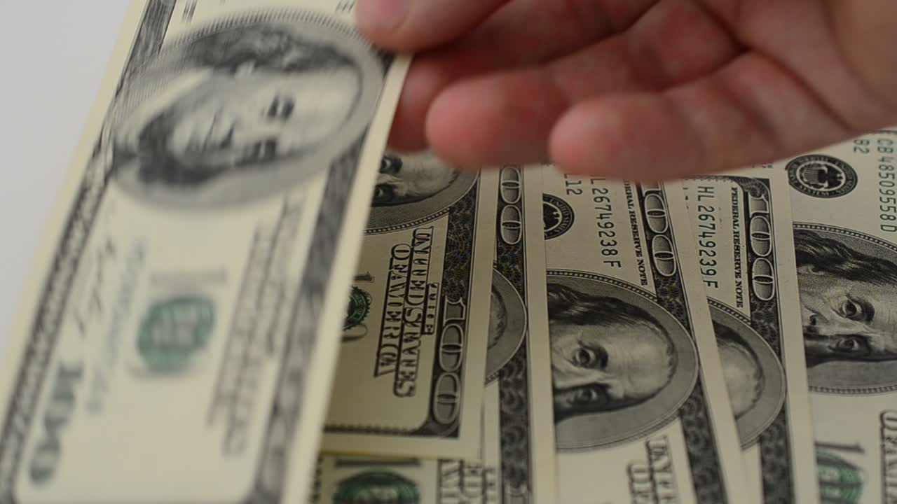 Dollari su sfondo bianco. Riprese in movimento.