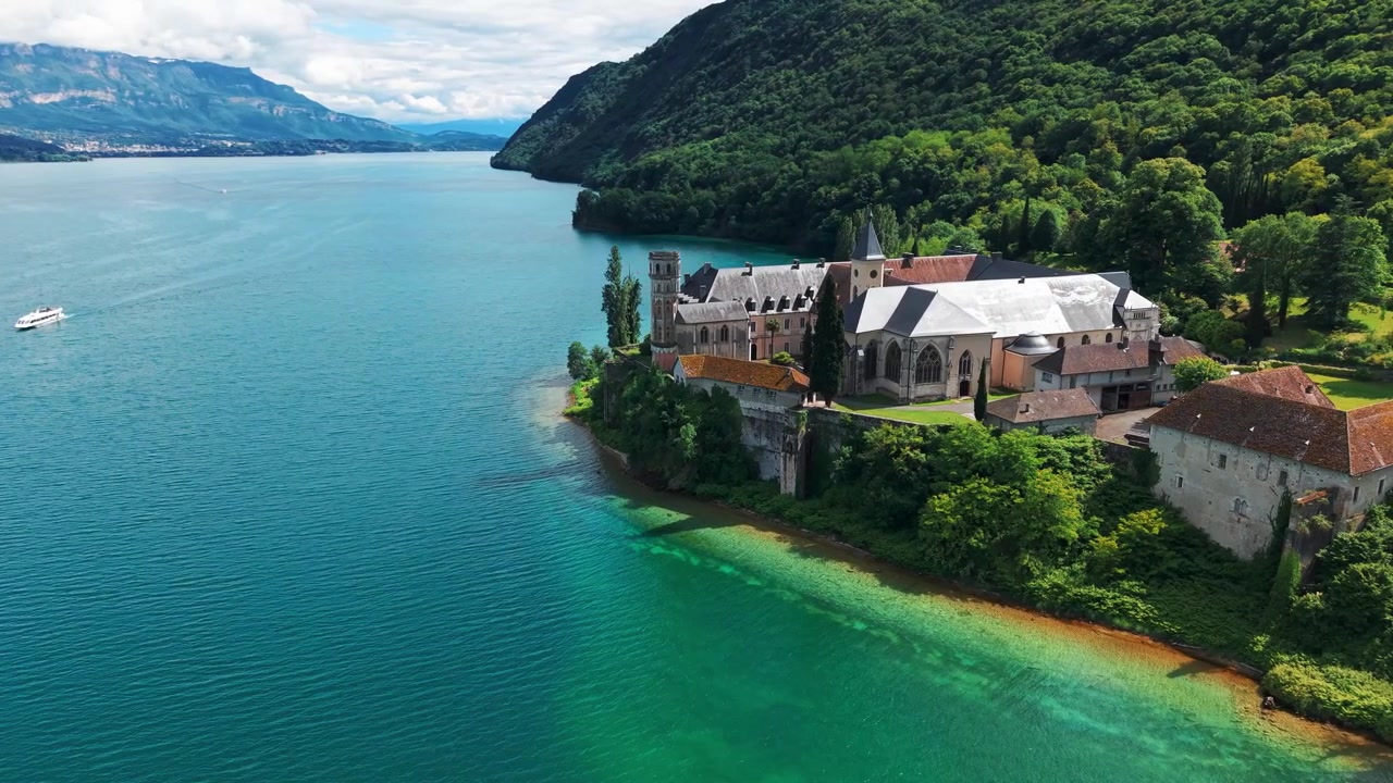 Ujęcie z lotu ptaka wokół Królewskiego Opactwa Hautecombe na brzegach jeziora Lac du Bourget w słoneczny dzień, departament Sabaudia, region Owernia-Rodan-Alpy, Francja.