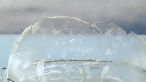 frozen broken soap bubble in cold light wind