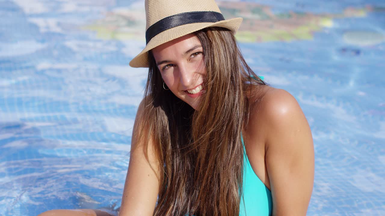 Smiling long haired beauty wearing bikini and hat