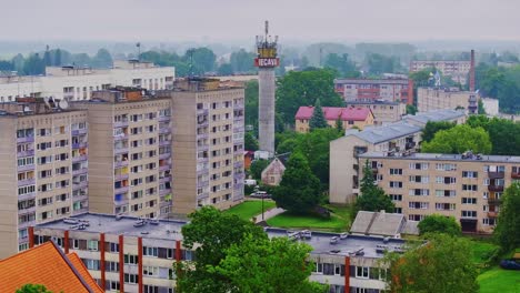 Camera pans left across residential Iecava as tower and Lutheran church appear