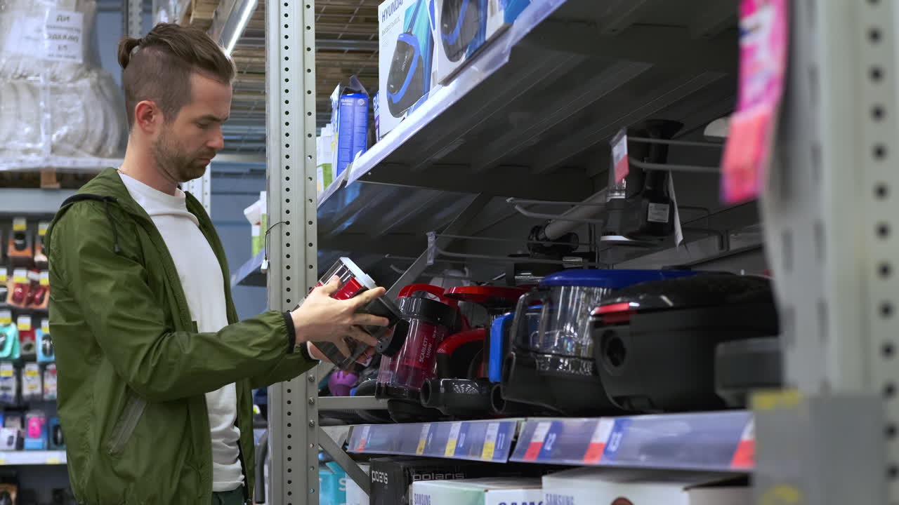 hombre comprando aspiradoras en una tienda minorista