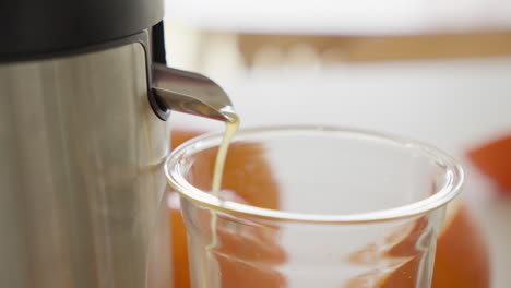 Jugo-De-Naranja-Vertiendo-En-Un-Vaso-De-Vidrio-Transparente-Del-Exprimidor-Eléctrico