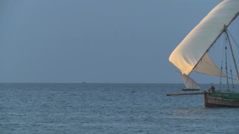 a dhow pirate ship sails past the coast of zanzibar