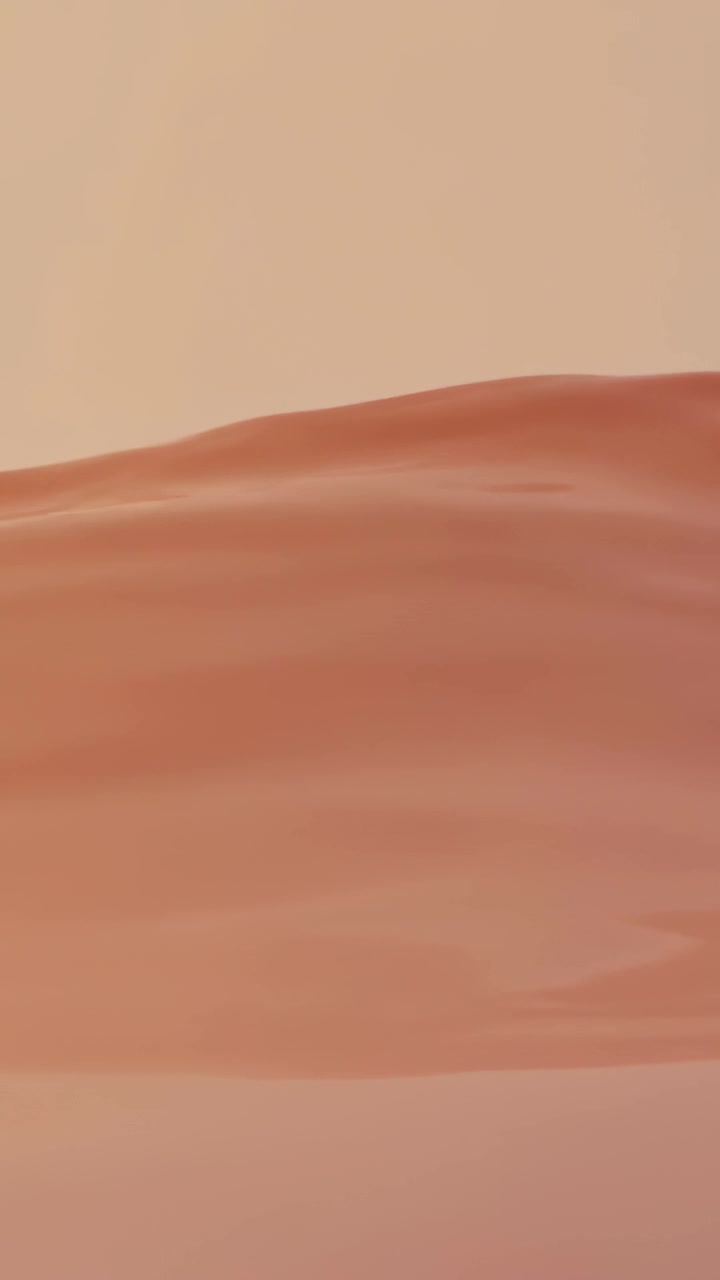 Video verticale: Telecamera che panoramica mostrando una cresta di dune che si sposta a destra attraverso una pianura calda, mostrando increspature.