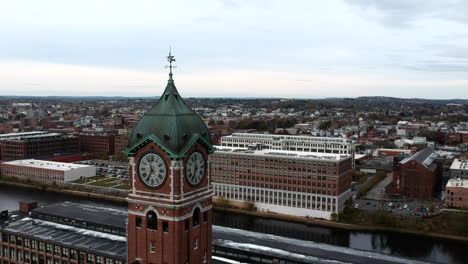 close up view of ayer mill clock tower with commercial and industrial buildings along merrimack river in the background in lawrence, massachusetts