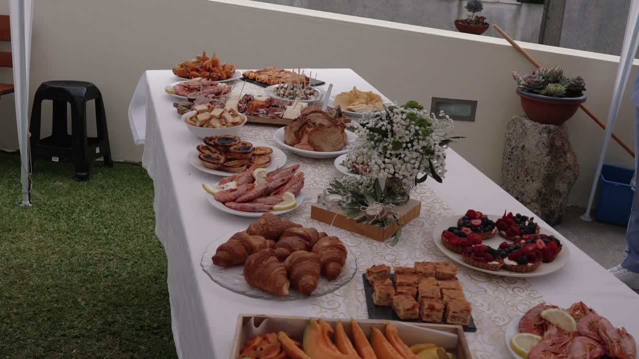 Buffet table with fruit pastries seafood and cold cuts prepared for an elegant outdoor event