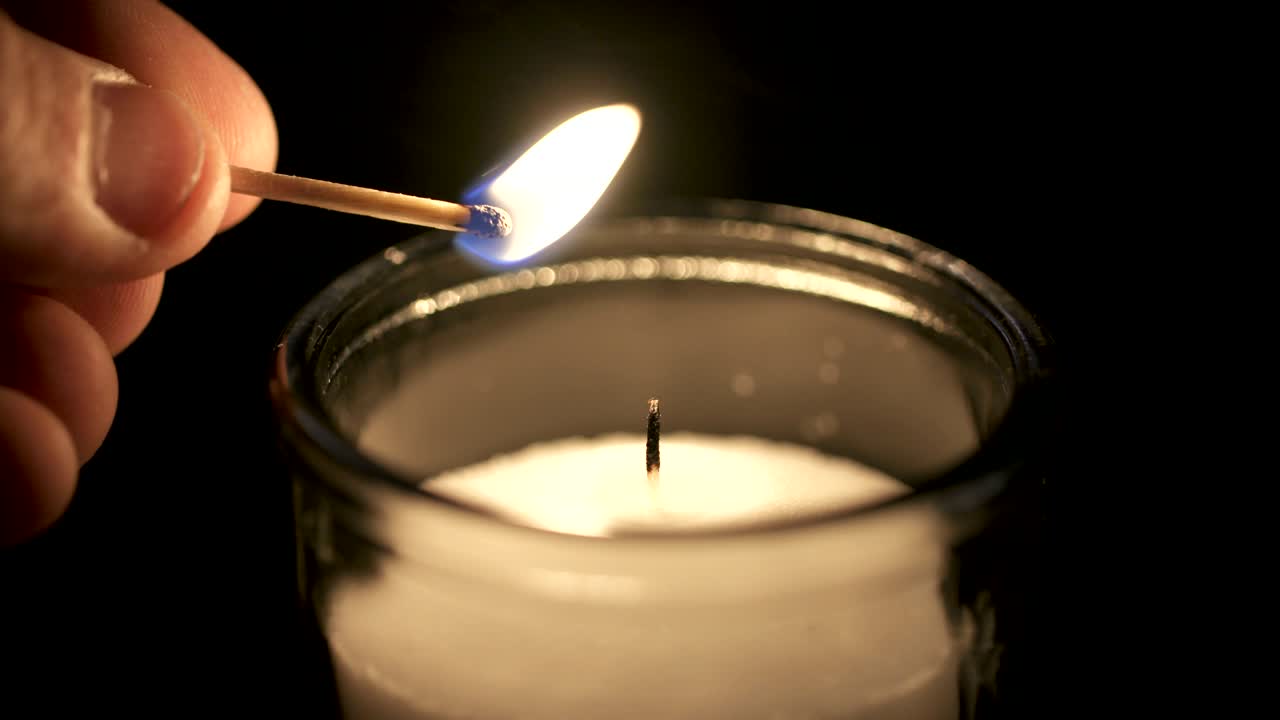 макрофильмы с замедленным движением белой свечи, зажженной спичкой на темном фоне