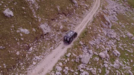 Arriba-Hacia-Abajo-De-La-Casa-Rodante-En-La-Pista-De-Tierra-En-El-Parque-Nacional-Durmitor-Montenegro,-Antena