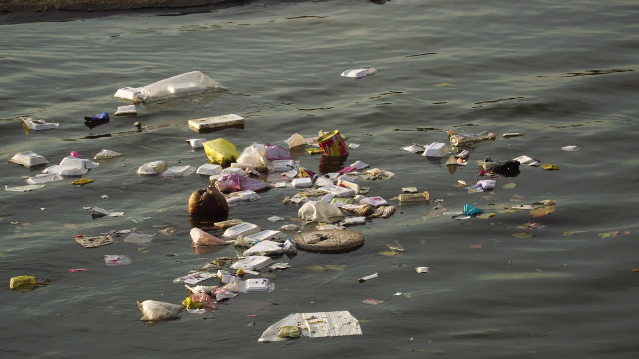 Close up, plastic garbage trash floating on river water