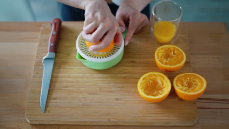 Frau-Macht-Natürlichen-Orangensaft-Auf-Einem-Holzbrett