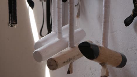 close up of wooden polo mallet head hung inside the stable