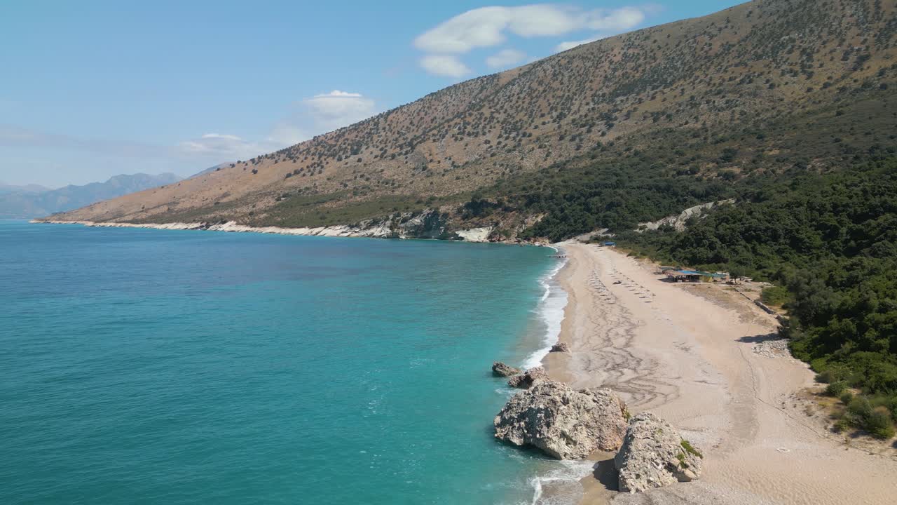 Drone ascends above rocky and white sand coastline in the Albanian Riviera