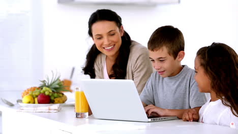 madre mirando la computadora portátil con los niños