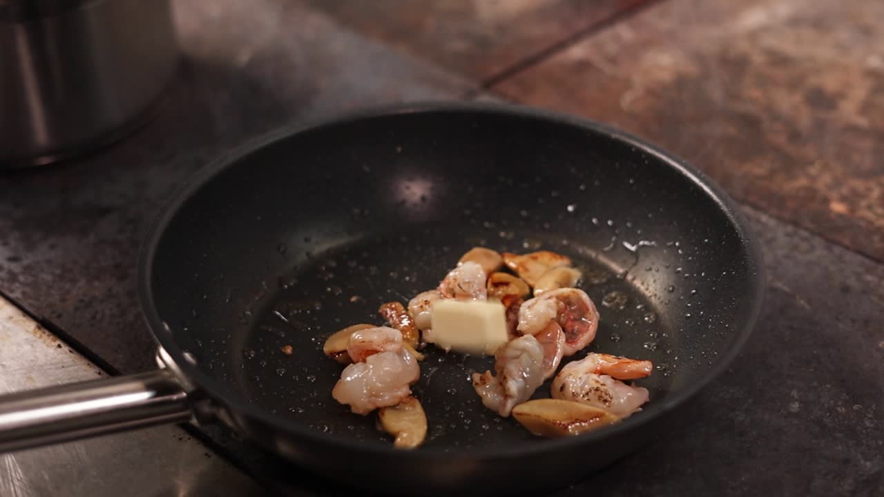 cocinar camarones y setas en una sartén