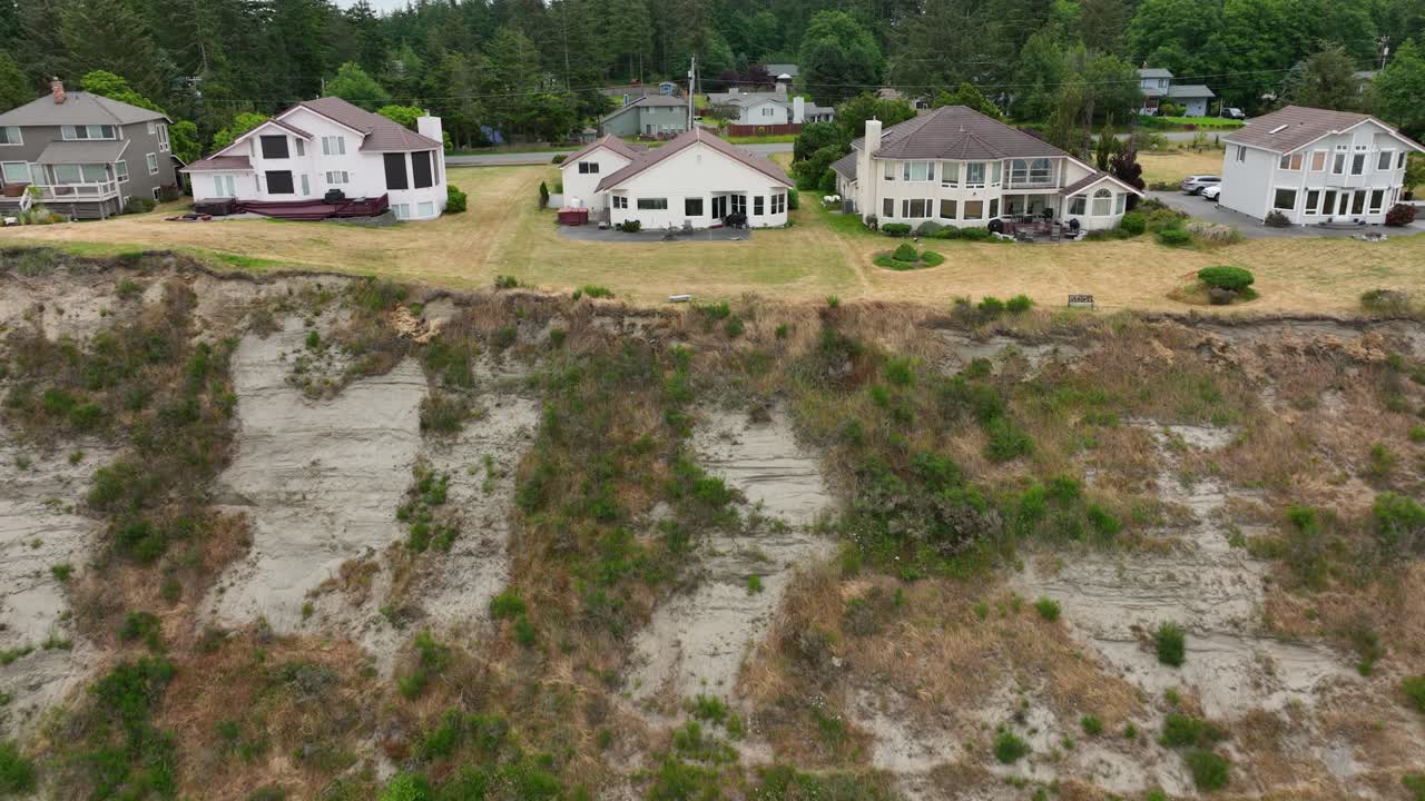 vista aérea de casas de vacaciones en la isla whidbey con el acantilado y el océano descansando debajo de ellas