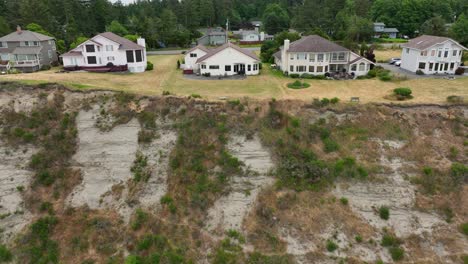 Vista-Aérea-De-Casas-De-Vacaciones-En-La-Isla-Whidbey-Con-El-Acantilado-Y-El-Océano-Descansando-Debajo-De-Ellas