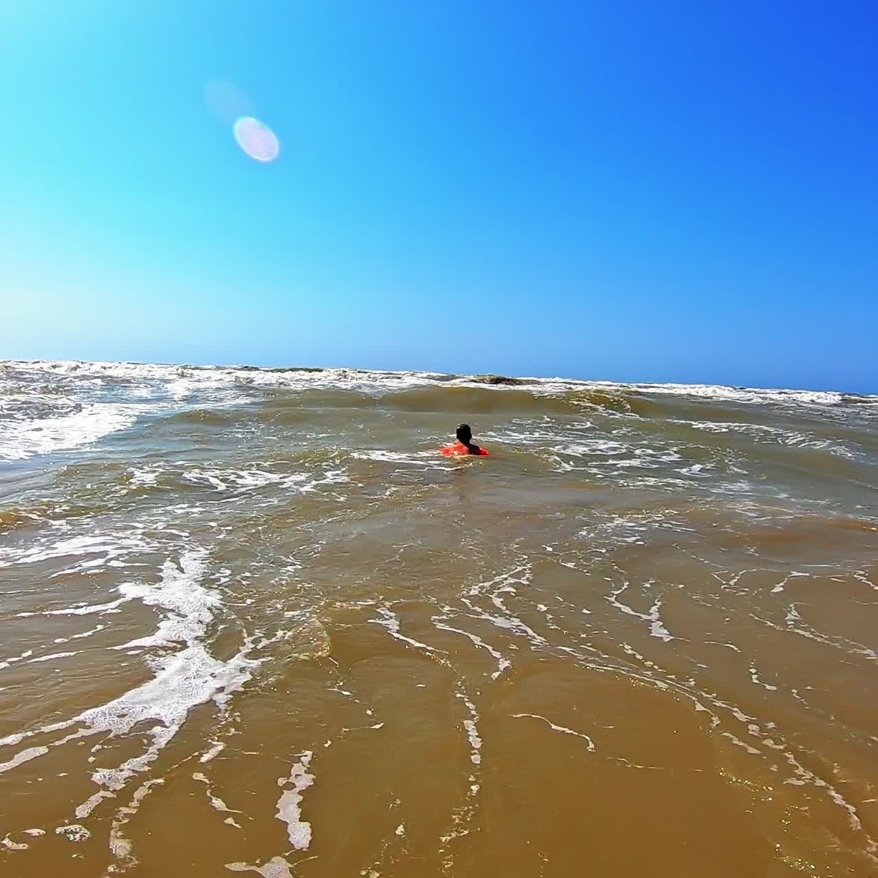 Dirty water with foamy waves in the sea. Child swimming in not clean sea water in summer time.