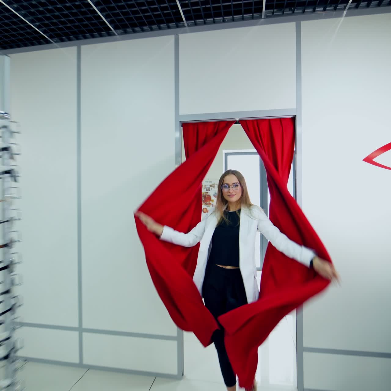 Young model posing in new eyeglasses. Beautiful woman comes enchantingly wearing fashionable glasses into the optical store.