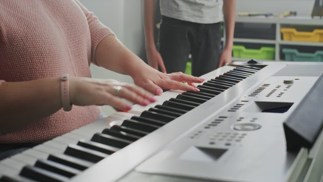 Close Up of Music Teacher Playing Piano Young Boy Practicing Vocals in Singing Lesson