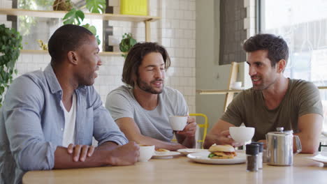 three male friends meeting in coffee shop shot in slow motion