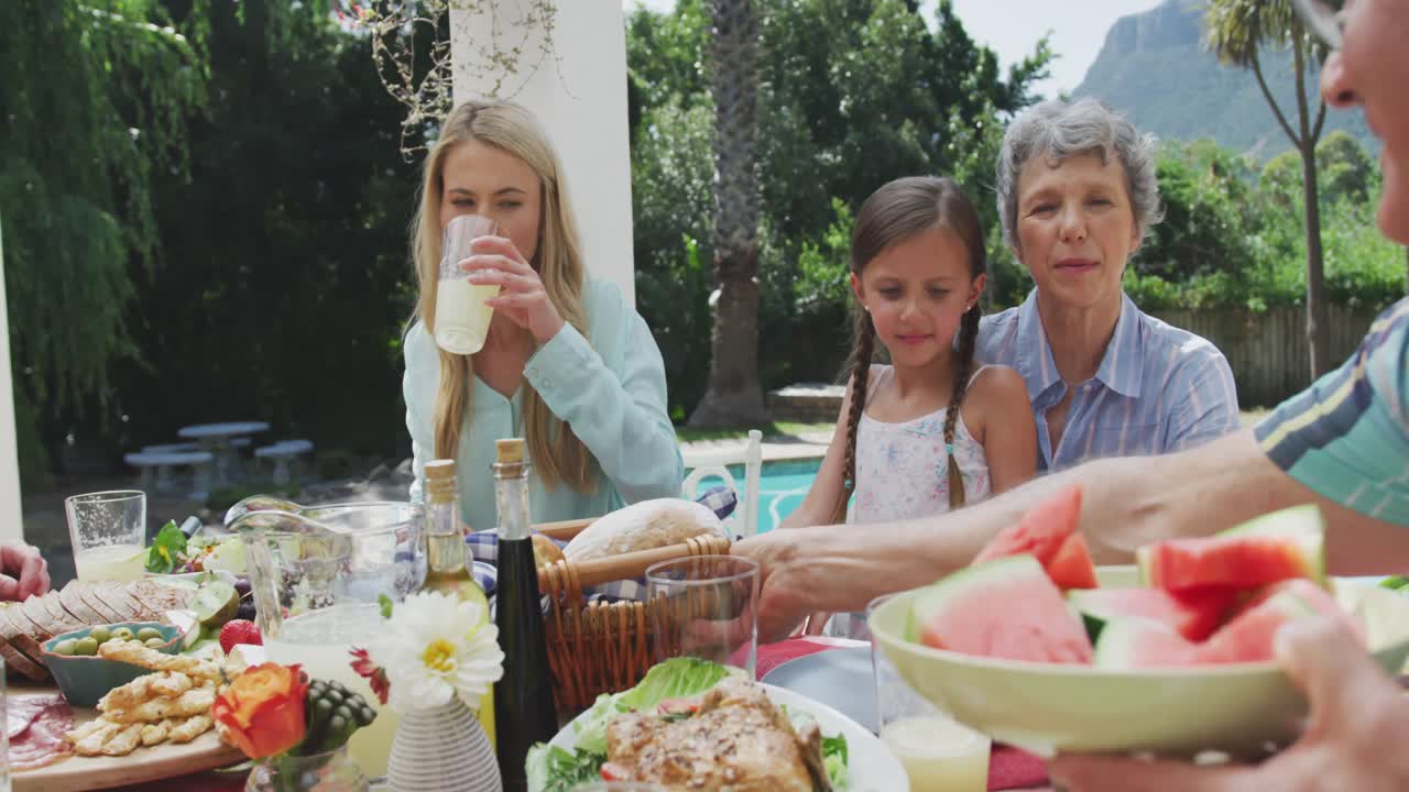 Glad familie spiser sammen ved bordet