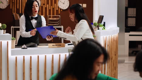 huésped del hotel firmando papeles de registro en la recepción