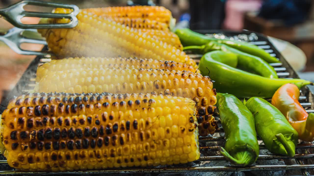cinemagraph de humo emitido por la cocción de maíz y pimienta verde en una parrilla de barbacoa caliente