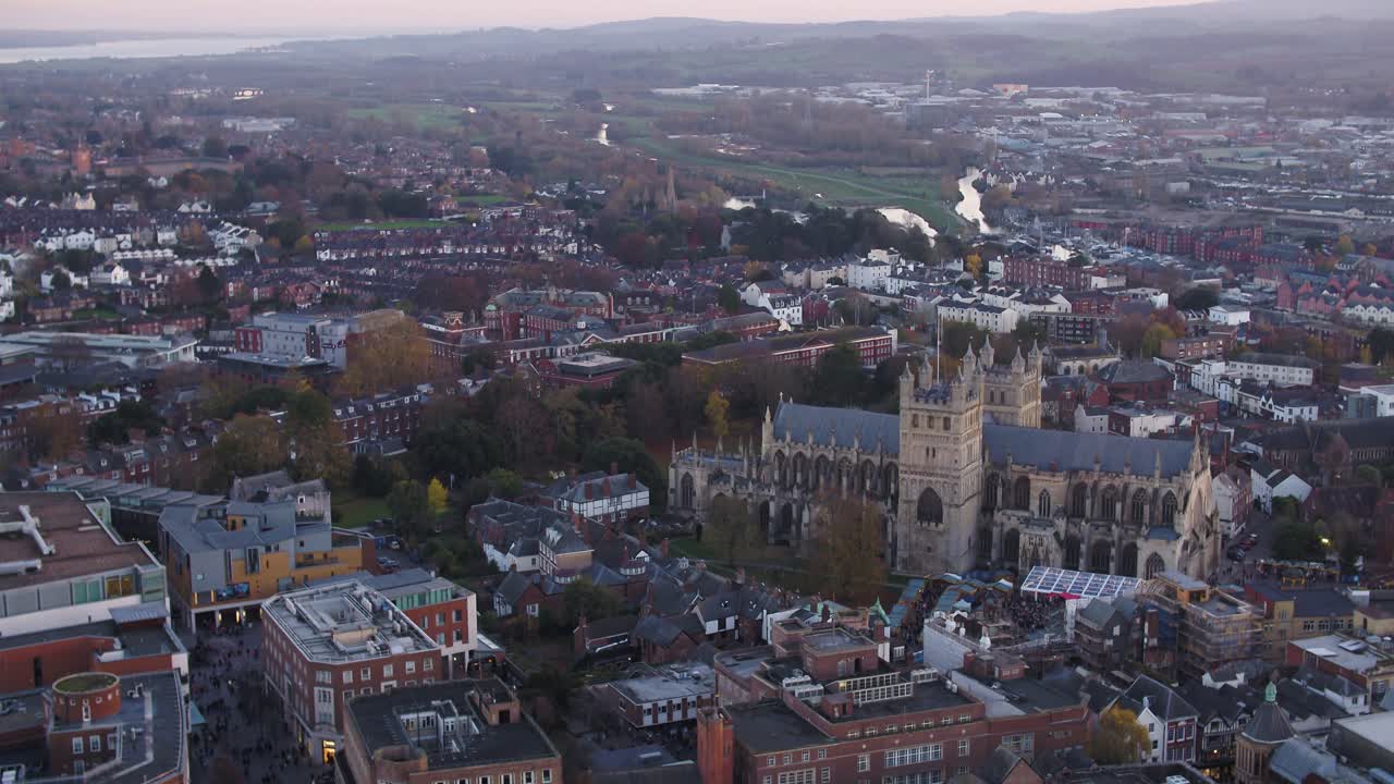 Evening aerial of a busy exeter city centre. A market taking place on the cathedral green