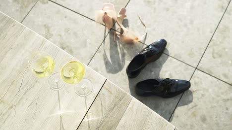 glasses of champagne and the bride and groom wedding shoes rotating view
