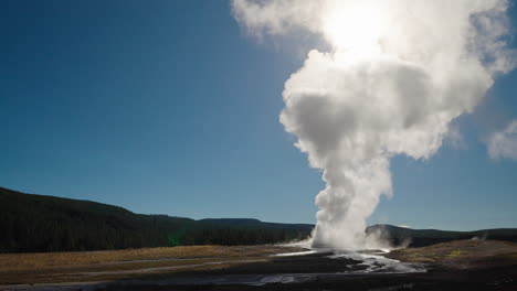massive steam eruption from a geyser in a natural landscape
