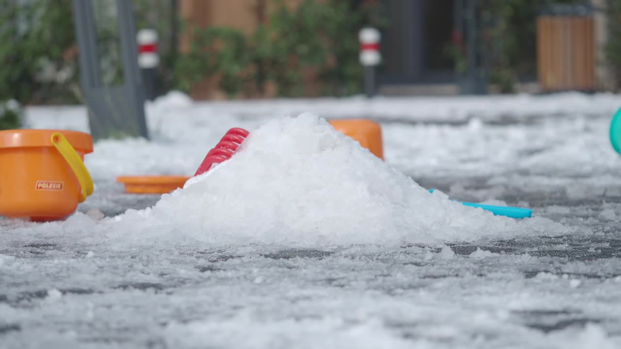 Hail piled up next to children's toys